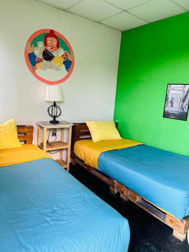 two beds in a room with green and yellow at Maison Verte - Budget Edition in Arequipa