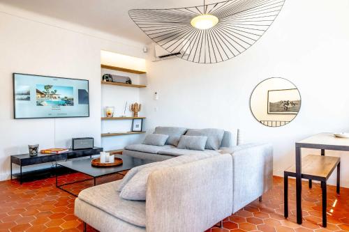 un salon avec un canapé et une table dans l'établissement Le Louis l Rooftop Views l Shellter Rentals, à Saint-Tropez