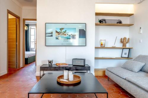 un salon avec un canapé et une table dans l'établissement Le Louis l Rooftop Views l Shellter Rentals, à Saint-Tropez