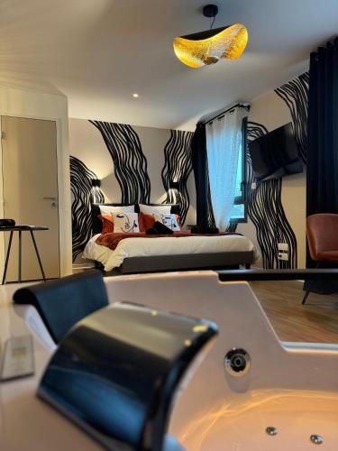 une chambre avec un lit et une baignoire dans l'établissement Suite romantique - Jolies Courbes, à Broons
