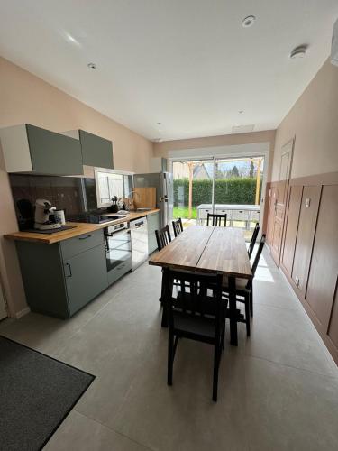 une grande cuisine avec une table et des chaises en bois dans l'établissement Cottage Dolce vita à Bobital, à Bobital