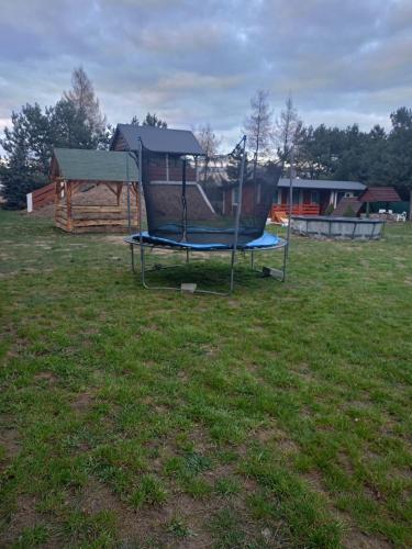 a playground in a field with a swing at Chatka u Patryka in Nowe Miasto