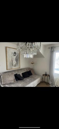 a bedroom with a bed and a chandelier at Appartement bord de mer in Jullouville-les-Pins