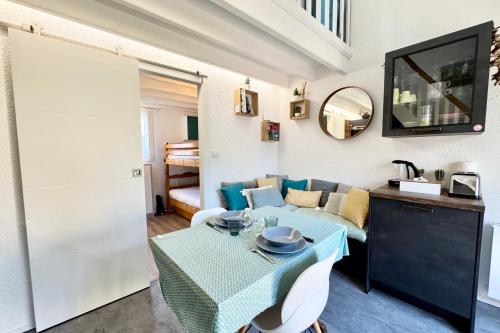 een woonkamer met een tafel en een bank bij Maisonnette de charme Bord de mer Piscine in Guidel