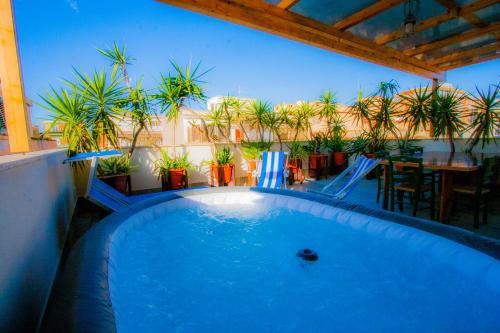 a swimming pool on a patio with a table and plants at Old Style by the sea, roof terrace with pool and kitchen, Ladispoli in Ladispoli