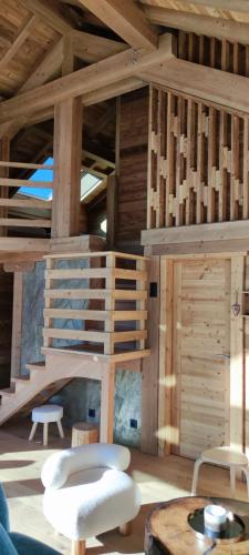 a living room with wooden walls and a spiral staircase at Lumen Wood in La Bresse