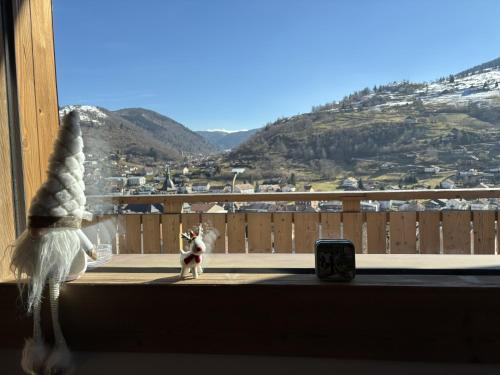 a dog standing in a window sill looking out at a mountain at Lumen Wood in La Bresse