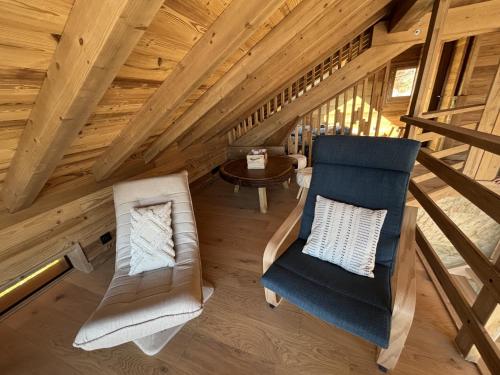 a room with a couch and a chair in a attic at Lumen Wood in La Bresse