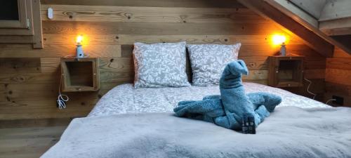 a stuffed animal on a bed in a bedroom at Lumen Wood in La Bresse