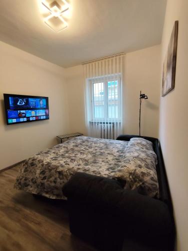 a bedroom with a bed and a flat screen tv at Biella Living in Biella