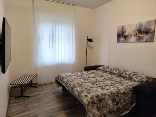 a bedroom with a bed and a table and a window at Biella Living in Biella