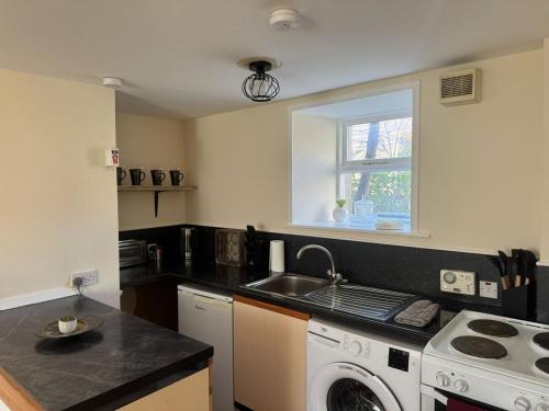 a kitchen with a sink and a washing machine at House in the heart of Kirkwall OR00575F in Orkney