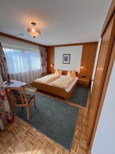 a bedroom with a bed and a table and a chair at Pension Haidachhof in Reith im Alpbachtal