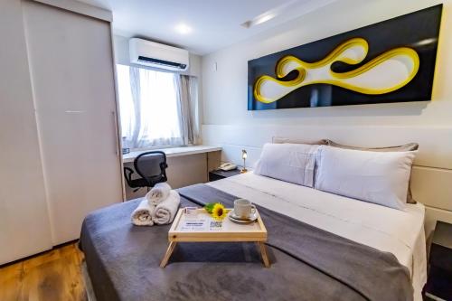 a bedroom with a large bed with a table on it at Ozped Private Flats Comfort Suites in Brasília