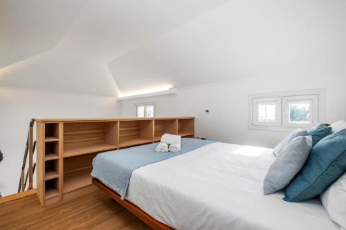 a bedroom with a large bed with blue pillows at Casa os Gauleses in Gaula