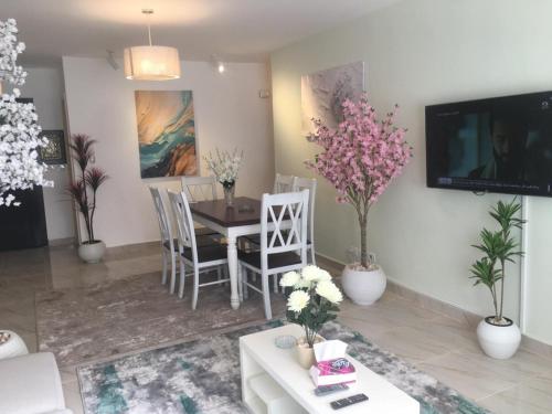 a living room with a table and chairs and a tv at Casa De Madinaty -مدينتي in Madinaty