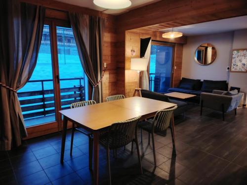 un salon avec une table et un canapé dans l'établissement Appartement 3 chambres au doux soleil, aux Gets