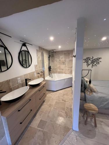 une salle de bain avec deux lavabos et une baignoire dans l'établissement La Ganterie - Berges du Tarn, à Millau