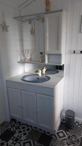 une salle de bain avec un lavabo et un miroir dans l'établissement Châlet en bois à 800m de la mer, à Sarzeau