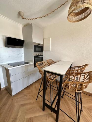 une cuisine avec une table et des chaises dans une pièce dans l'établissement À pied à la plage & vue mer, à Grimaud
