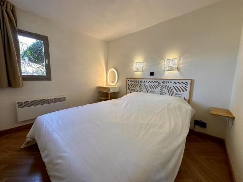 une chambre avec un lit blanc et une fenêtre dans l'établissement À pied à la plage & vue mer, à Grimaud