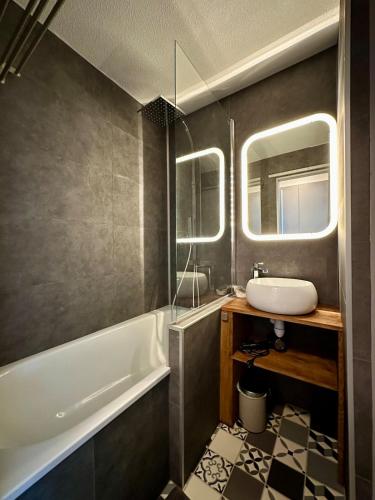 une salle de bain avec une baignoire et un lavabo et une baignoire dans l'établissement À pied à la plage & vue mer, à Grimaud