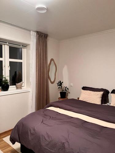 a bedroom with a large bed and a window at Cozy house with sea view in Havsteinen