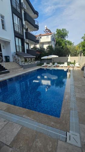 a large swimming pool in front of a building at Turkuaz sitesi 2 odalı eşyalı ve havuzlu manzaralı kişi fiyatı değil oda fiyatı in Side
