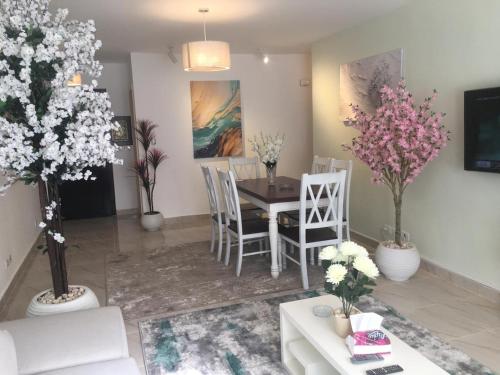 a living room with a table and chairs and flowers at Madinaty Home in Madinaty