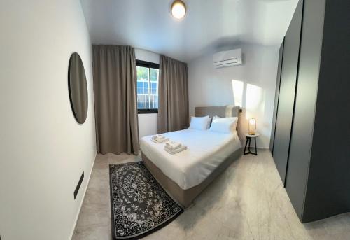 a small bedroom with a white bed and a window at Lux Level 4 Penthouse Tower 206 in Nicosia