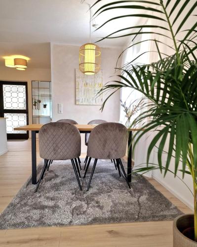 a dining room table with chairs and a potted plant at WillingenHOME in Willingen