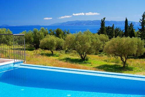 a blue swimming pool with a view of the water at Vista Blu Villa in Vlachata