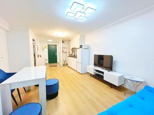 un salon avec une télévision, une table et des chaises dans l'établissement Apartment Le Marais, à Paris