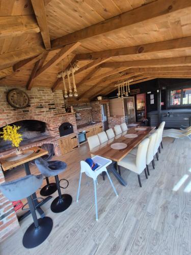 a dining room with a table and chairs and a fireplace at Kuca za odmor Ana in Brežane Lekeničke
