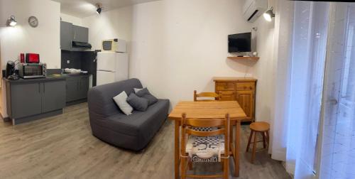 un petit salon avec un canapé et une table dans l'établissement Studio avec Jardin, à Gréoux-les-Bains