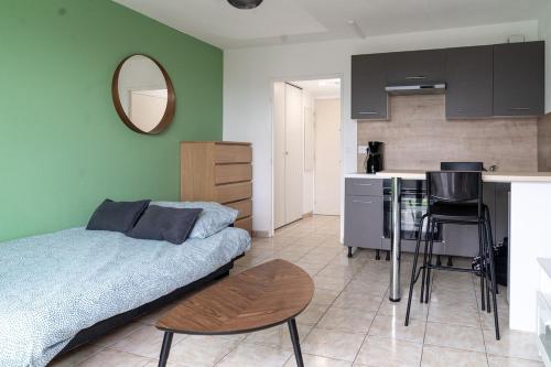 une chambre avec un lit et une table et une cuisine dans l'établissement Studio équipé dans une résidence avec piscine à 10mn du centre ville, à Nice