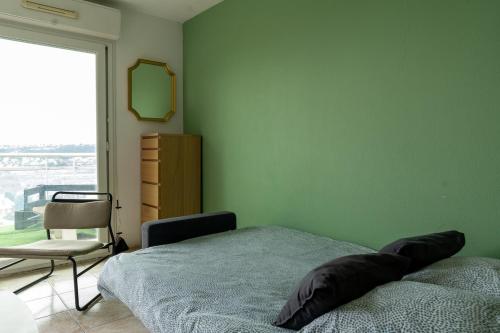 une chambre avec un lit, une chaise et une fenêtre dans l'établissement Studio équipé dans une résidence avec piscine à 10mn du centre ville, à Nice