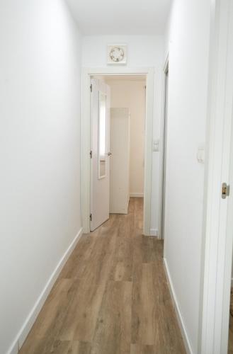 an empty hallway with white walls and wood floors at Zabas FLAT in Alboraya