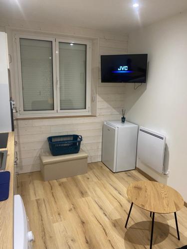 Il comprend une cuisine équipée d'un réfrigérateur et une télévision murale. dans l'établissement Le lodge, à Dole