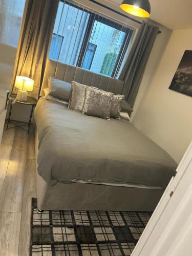 a bed in a room with a large window at 4 star Rating 2 bed Newly renovated city apartment with free parking in Belfast