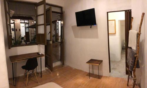 a room with a desk and a television and a mirror at Villa Mediterranea in Campeche