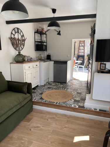 un salon avec un canapé et une cuisine dans l'établissement La tête dans les étoiles, à Aumont