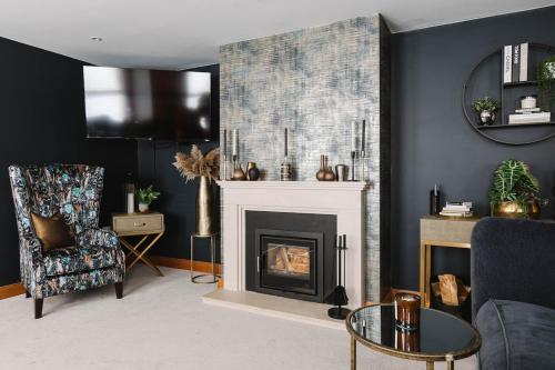 a living room with a fireplace and a chair at Tobela House, Sleeps 10, Ultra Luxury in Lambeg