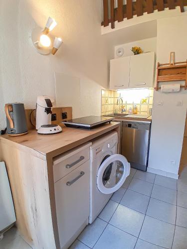 une cuisine avec un lave-linge et un réfrigérateur dans l'établissement Y'Hôtes conciergerie - studio les habères à 5min à pieds des pistes de ski, à Habère-Poche