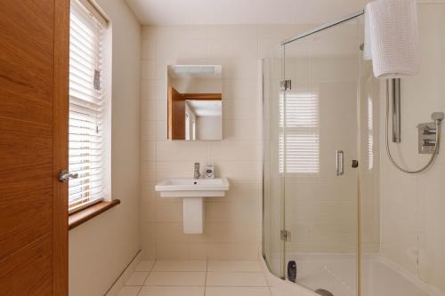 a bathroom with a sink and a shower at Tobela House, Sleeps 10, Ultra Luxury in Lambeg