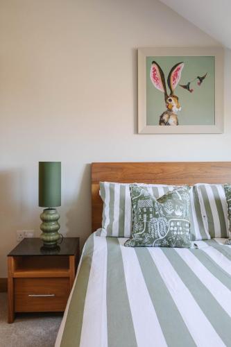 a bedroom with a bed and a night stand with a lamp at Tobela House, Sleeps 10, Ultra Luxury in Lambeg