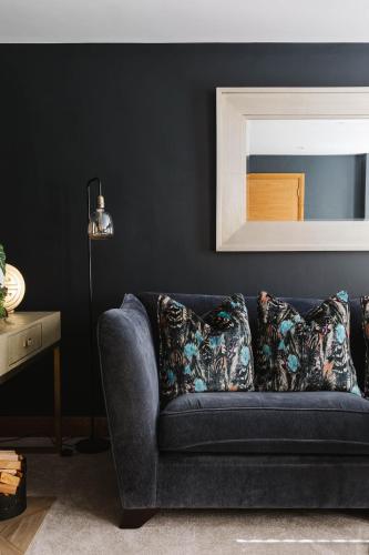 a blue couch in a living room with a mirror at Tobela House, Sleeps 10, Ultra Luxury in Lambeg