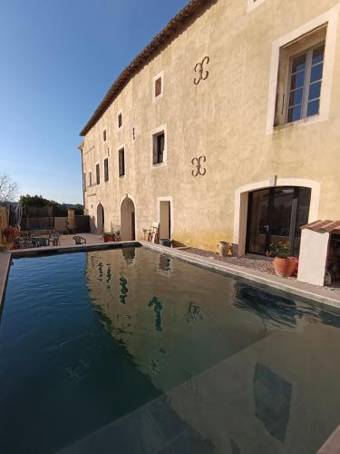 une grande piscine devant un immeuble dans l'établissement House in a private estate, à Sommières