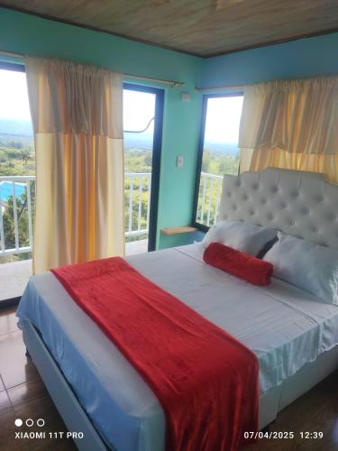 a bedroom with a large bed with a large window at alojamiento campestre DESCANSO TOTAL in Filandia