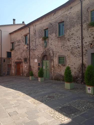 a large brick building with a green door at Agriturismo Palazzo Vescia in Quercia di Aulla